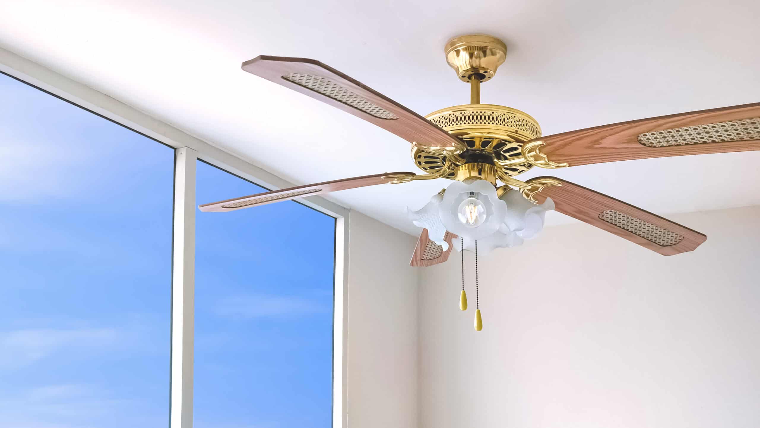 Ceiling fan with four wood-patterned blades seamlessly enhancing any outdoor lighting design.
